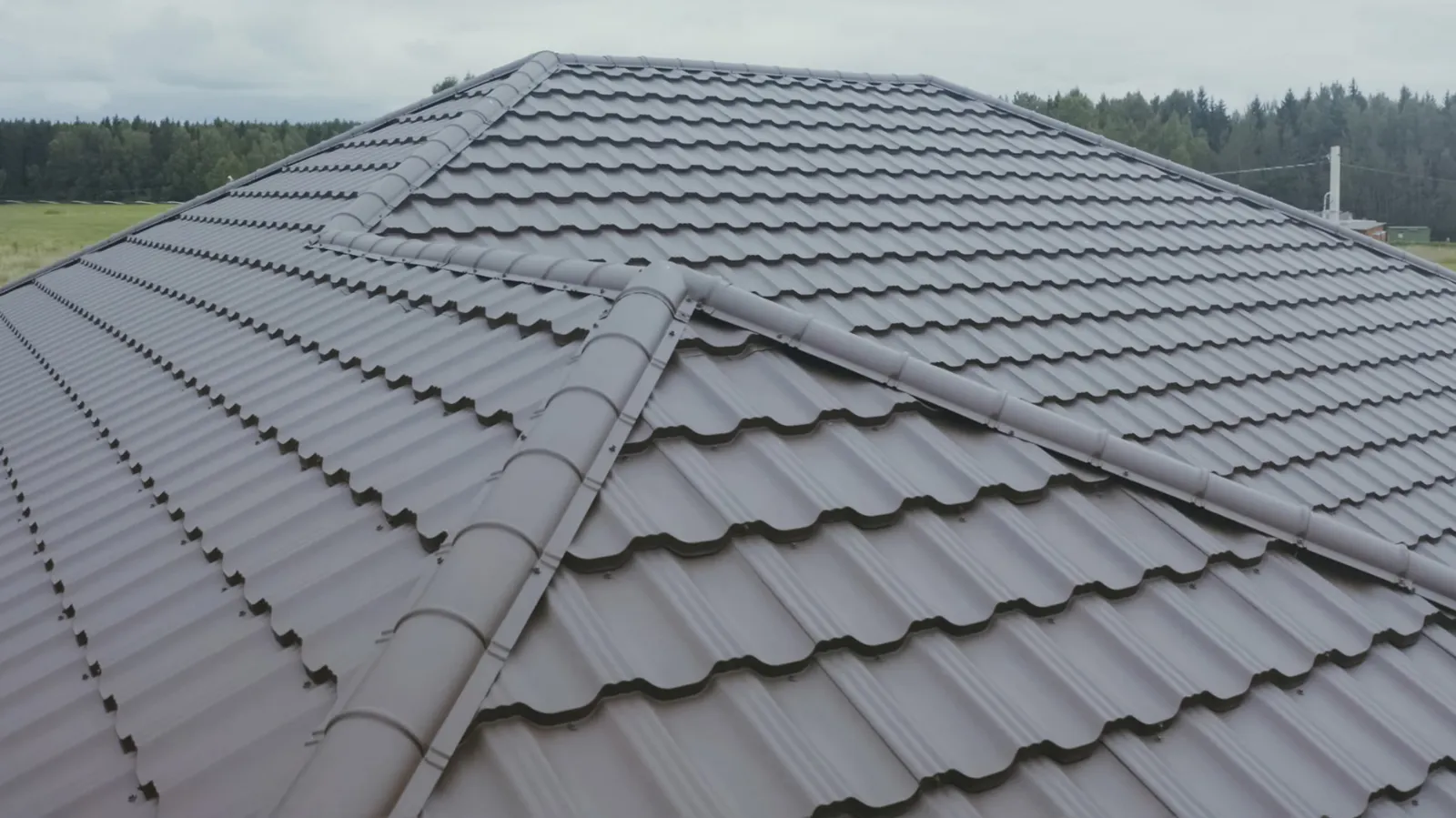 Brown metal tile roofing with ridge caps on a hip roof