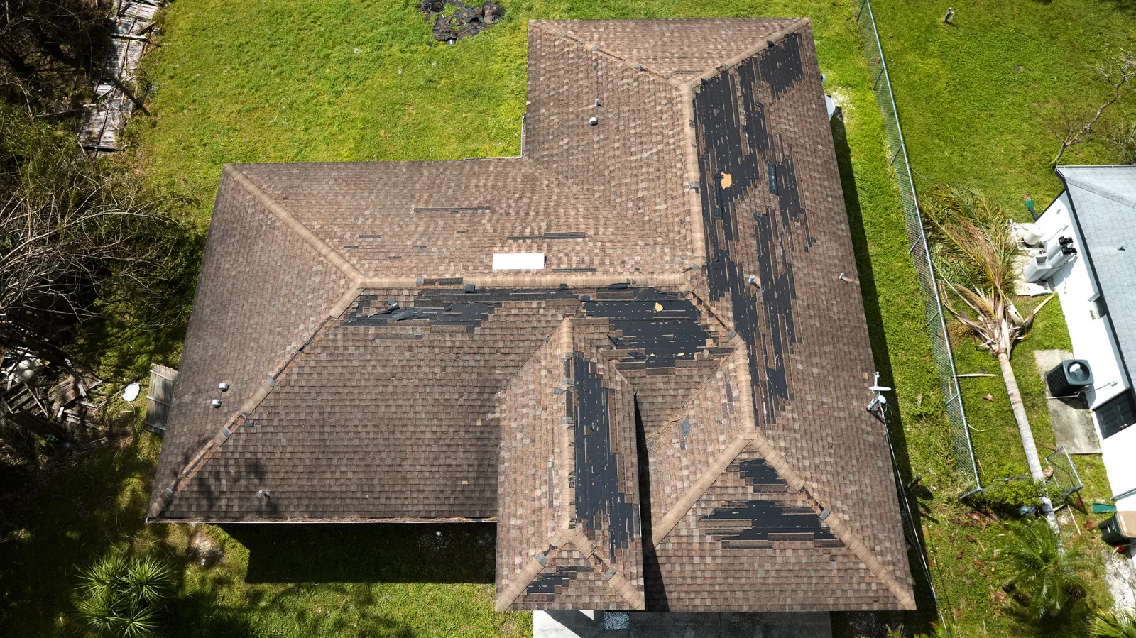 Many torn-away shingles on a roof viewed from above